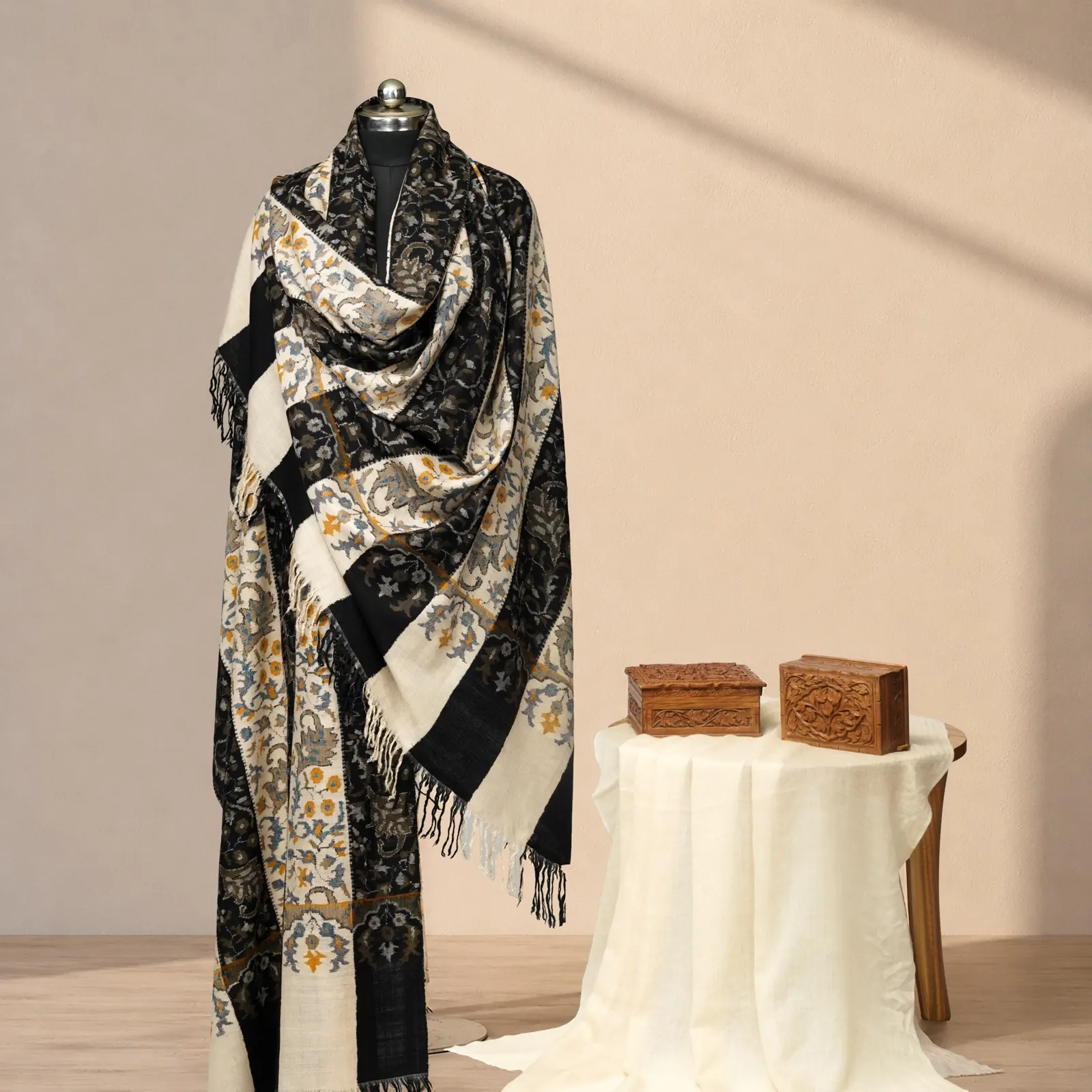 Shawl in alternating black and cream floral bands with gold and slate detail and a long fringe.