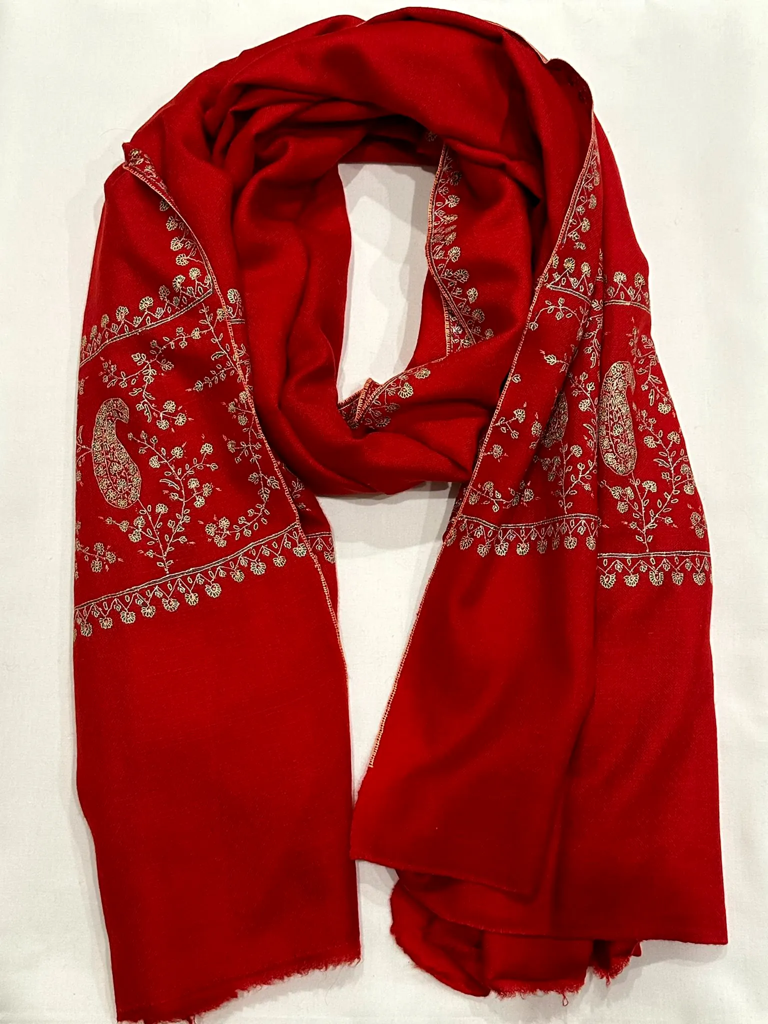 Red stole with ivory paisley needlework along the borders.