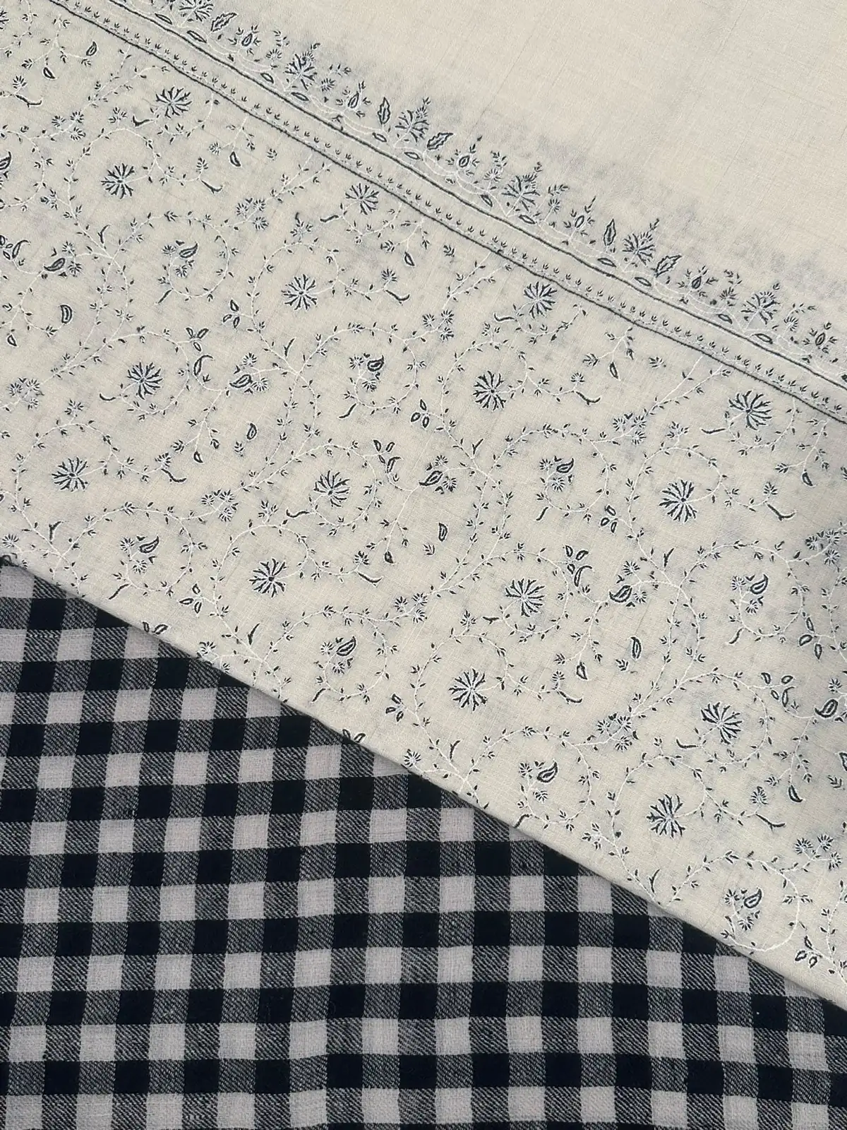 Ivory stole with grey sozni sprigs above a navy and white check stole.