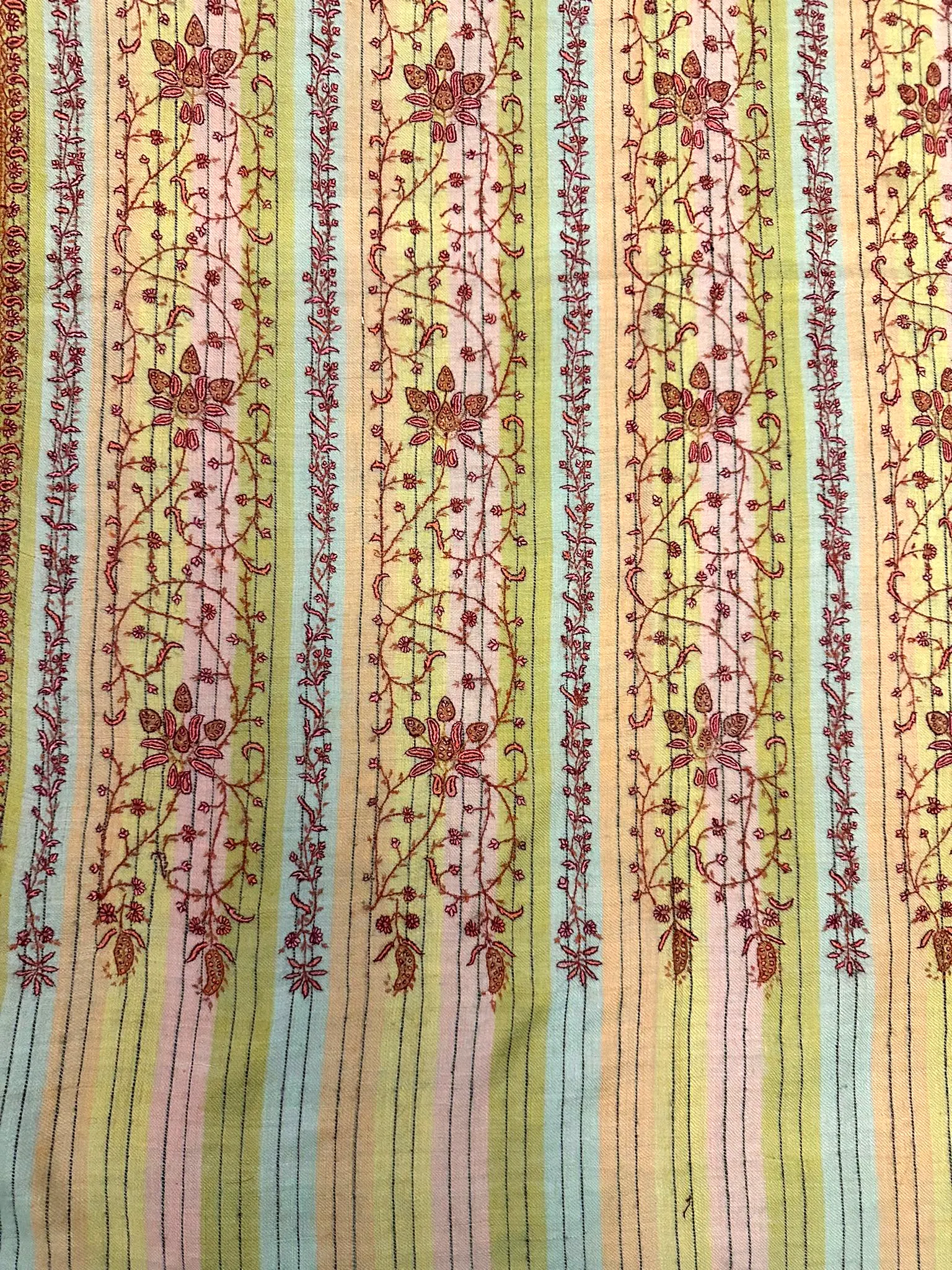 Flat view of the same shawl, showing the red vines running between pastel stripes.