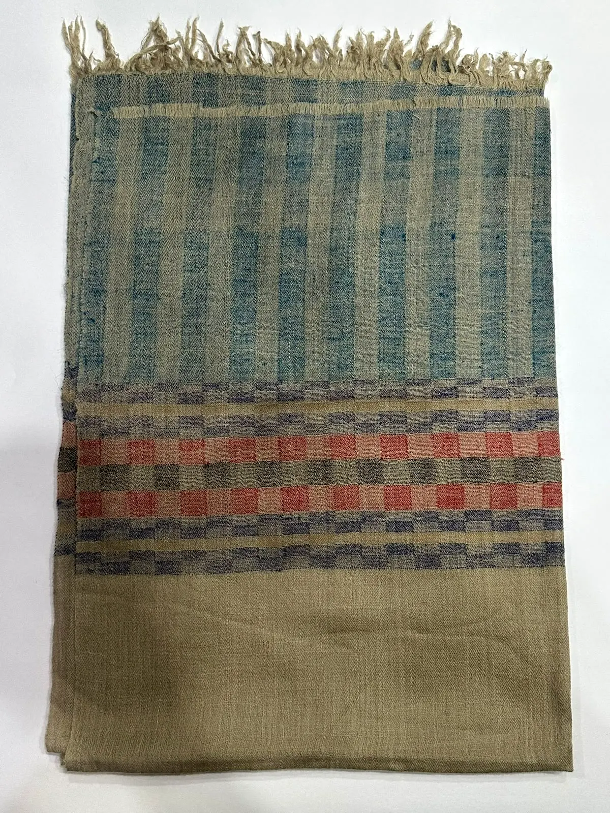 Folded sage check shawl with a red and navy check band and a fringe.