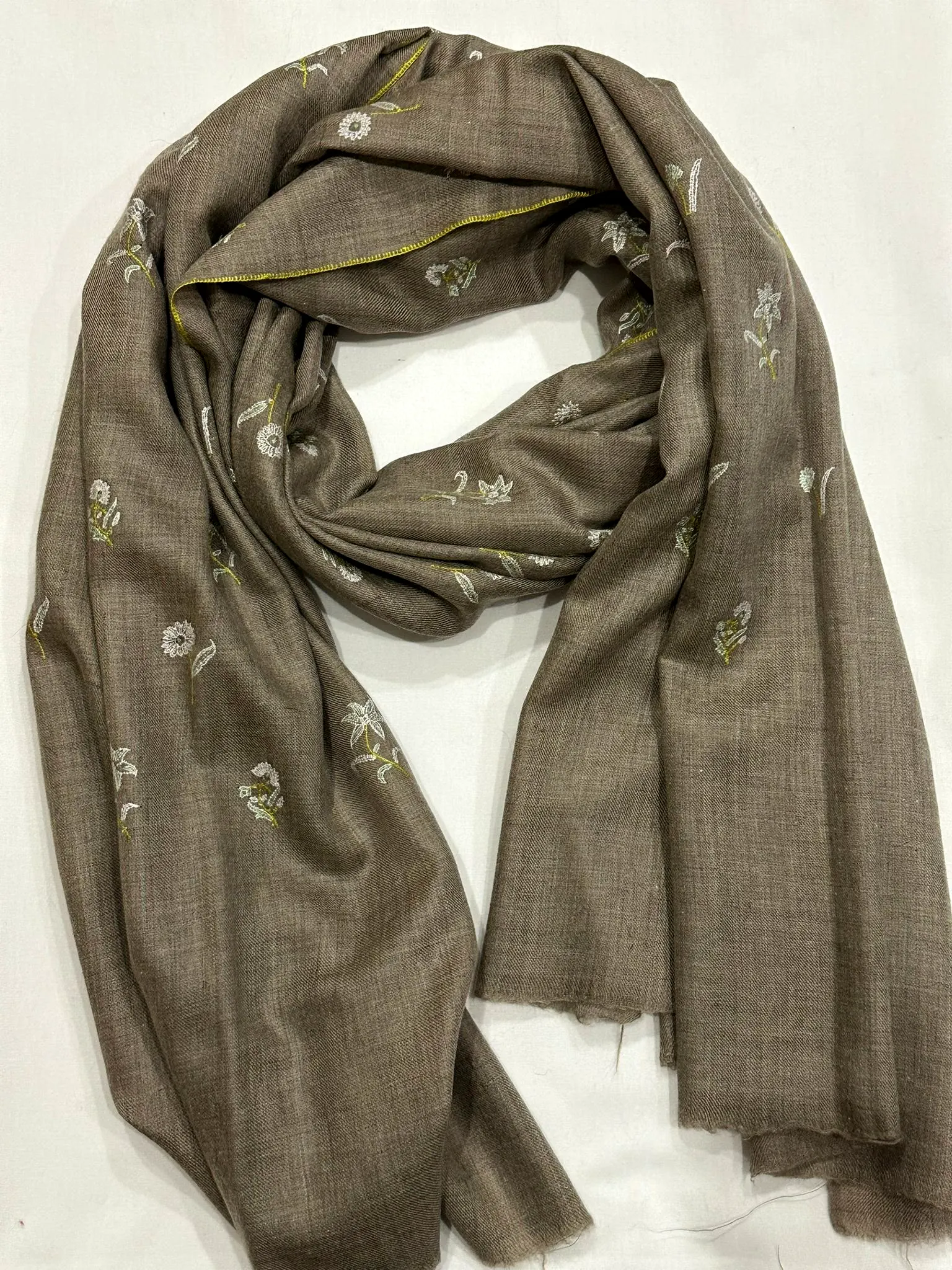Grey green stole with small coloured flower sprigs scattered across it.