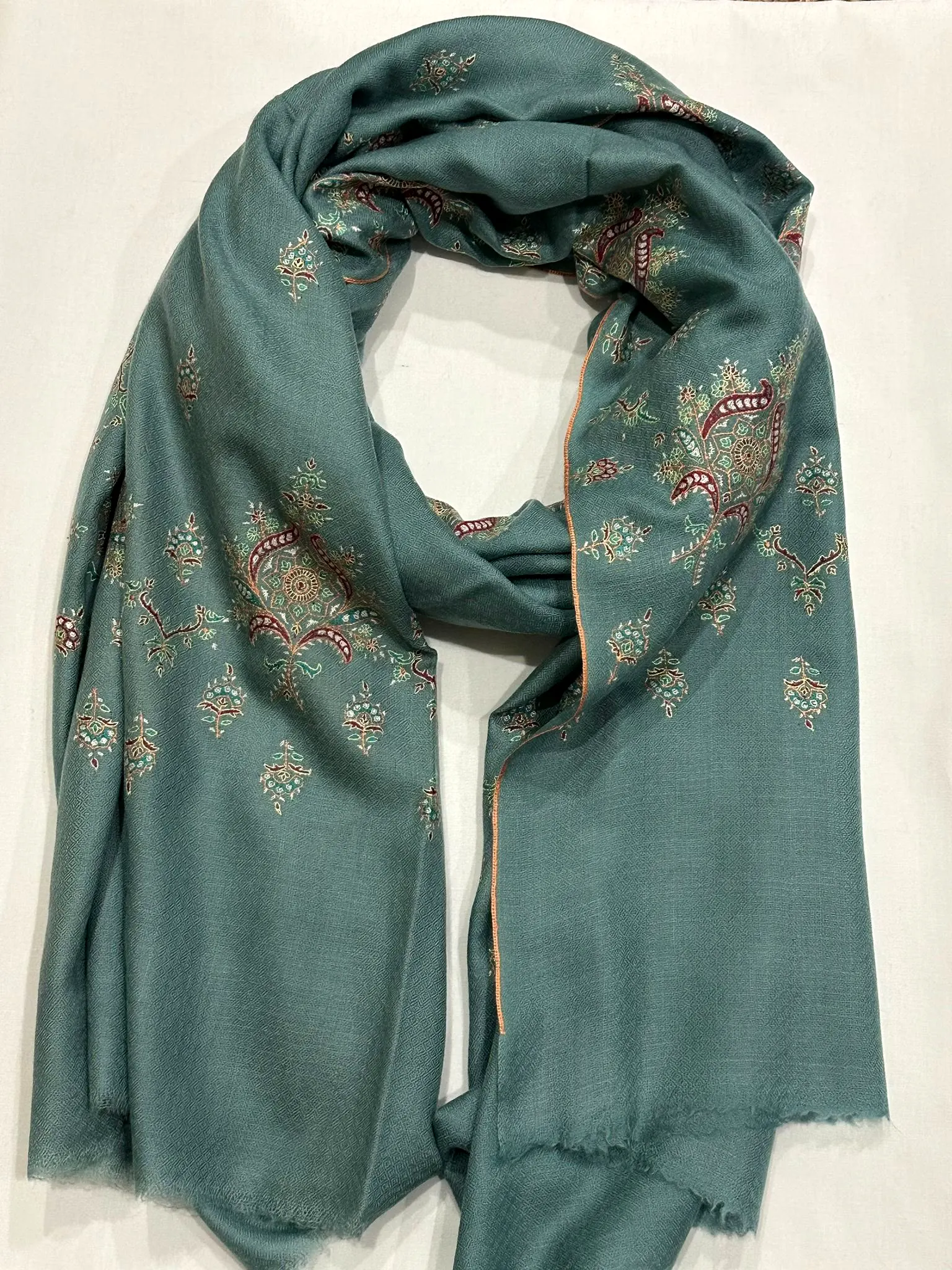 Grey green stole with small multicoloured needlework motifs.