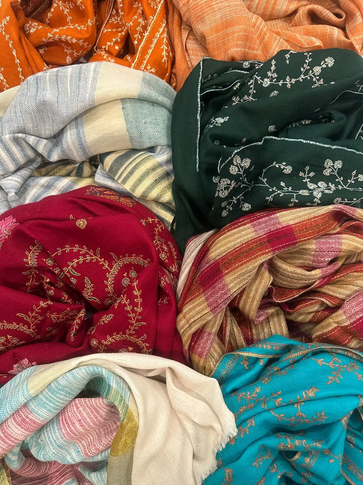 Folded stoles in green sozni, crimson sozni, checks and stripes.
