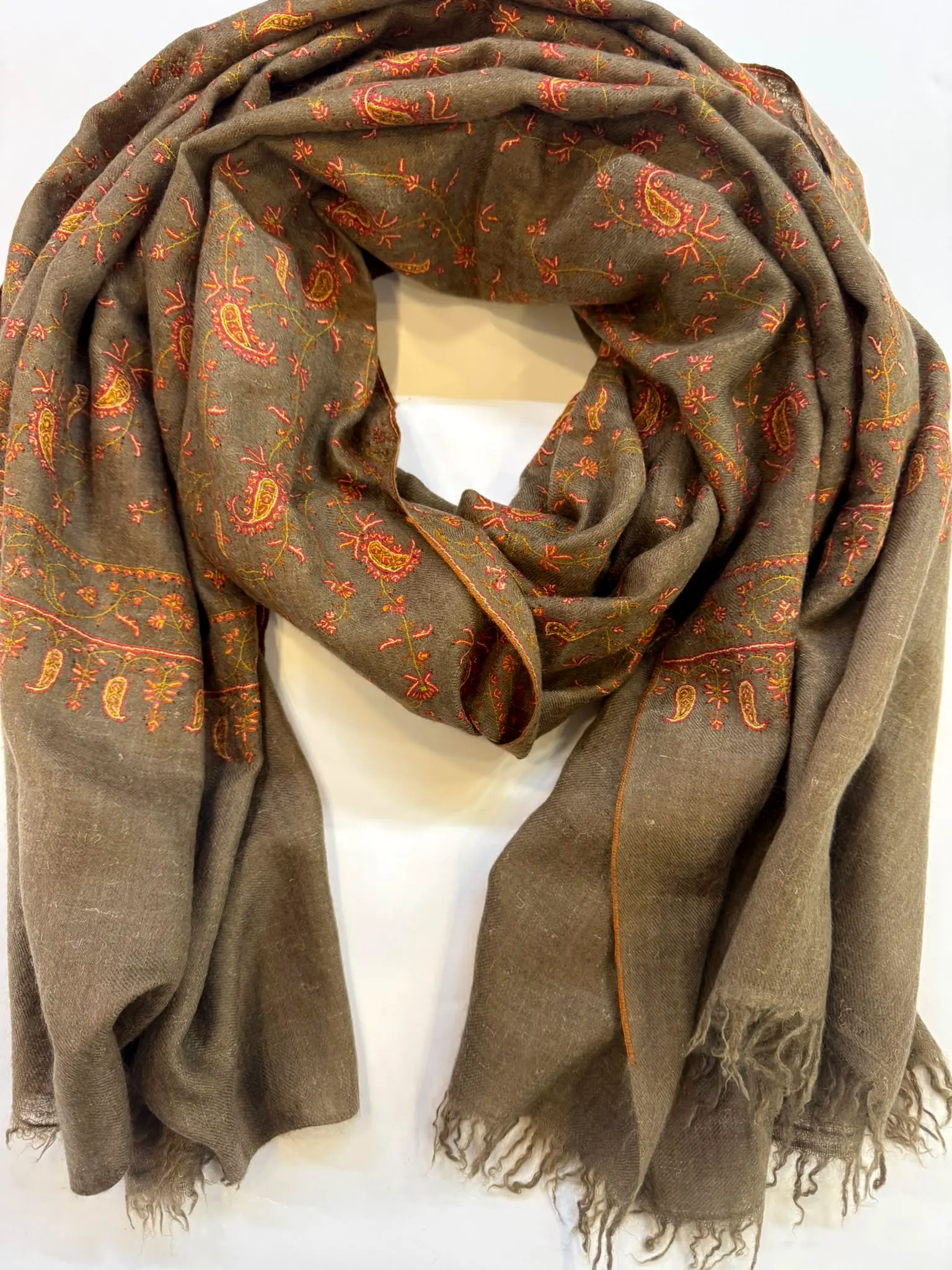 Taupe stole with coral and orange paisley needlework across the upper body and borders.