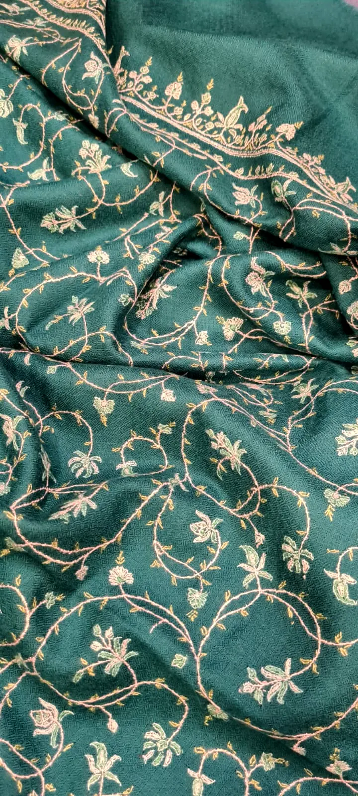 Teal shawl covered in ivory and pink vine needlework, with an embroidered border at the top.